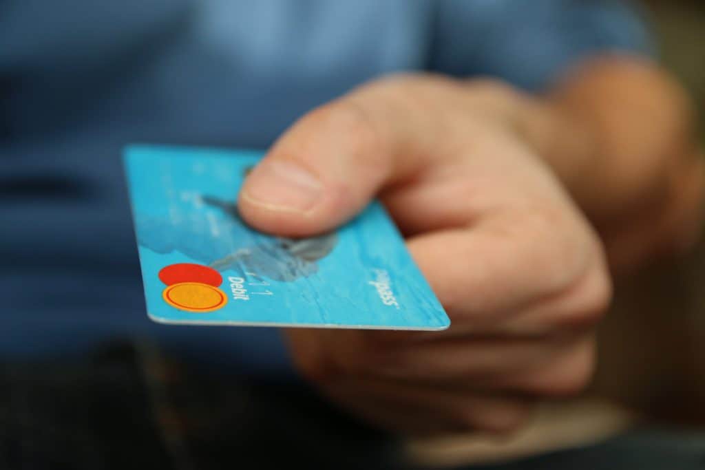 Hand holding a blue debit card.